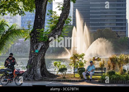 Les gens se détendent près de la fontaine et du lac dans Lumphini Park le dimanche après-midi, Bangkok, Thaïlande Banque D'Images