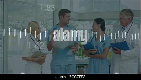 Discussion de l'équipe médicale examinant des films radiographiques dans le couloir de l'hôpital, avec des stéthoscopes et des planches à pince Banque D'Images