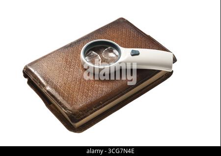 Vieux livre relié en cuir isolé sur blanc avec une loupe Banque D'Images
