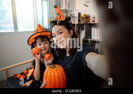Souvenirs d'Halloween. Mère et fille appréciant selfie festif avec des citrouilles. Banque D'Images