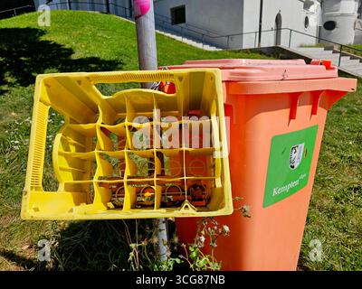 Aufnahme vom 25. Août 2025 Das Foto zeigt einen leeren gelben Getränkekasten, der an einem Mast befestigt ist und direkt neben einer orangenen Mülltonne steht. Die Mülltonne trägt ein Grünes Schild mit dem Stadtwappen sowie der Aufschrift Kempten Allgäu . Die Szene verdeutlicht die Einrichtung öffentlicher Müllentsorgungsstellen in Kempten eine soziale Maßnahme, die es ermöglicht, Pfandflaschen direkt in einem Getränkekasten abzustellen. *** Photo prise le 25 août 2025 la photo montre une caisse de boissons jaune vide attachée à un poteau et debout juste à côté d'une poubelle orange le gar Banque D'Images