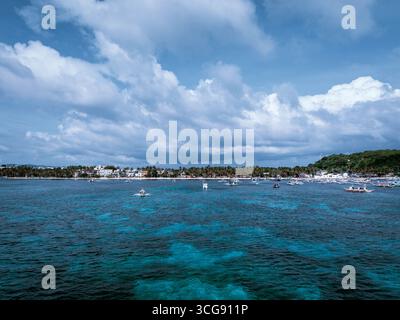 Vue aérienne des eaux turquoise rencontre les sables blancs de Boracay sous un vaste ciel nuageux, des bateaux parsemant le paysage marin, Malais, Visayas occidentales, Philippines. Banque D'Images
