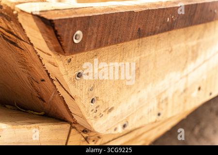Dakar, Sénégal - 12 mai 2025 : vue de planches de bois méticuleusement travaillées reliées par des rivets métalliques, créant des motifs géométriques et des textures. Banque D'Images