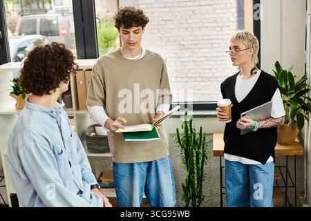 Trois jeunes personnes discutent des idées de manière productive dans un bureau dynamique. Banque D'Images