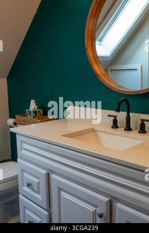 Un puits de lumière fournit une lumière chaude pour une salle de bains résidentielle compacte, Great Falls, Montana, 2025, États-Unis Banque D'Images