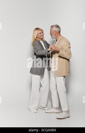 Élégant couple senior dansant joyeusement ensemble, mettant en valeur leur romance et leur connexion. Banque D'Images