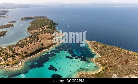 Vue aérienne à couper le souffle de la côte de Vourvourou à Sithonia, Grèce, montrant des bateaux jouissant d'une eau turquoise cristalline Banque D'Images