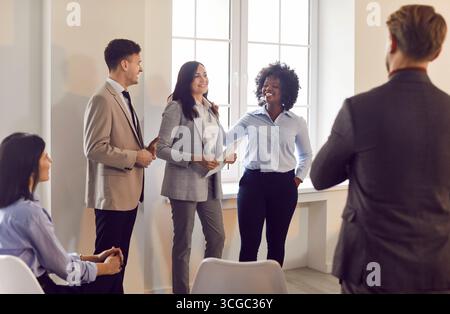 Équipe d'affaires multiraciale debout ensemble, à l'écoute des collègues, discutant de la stratégie de l'entreprise. Banque D'Images