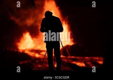 Un photographe réalise un cliché de deux fontaines de lave chaude tirant depuis le cratère Halemaumau et déversant de la lave dans la caldeira, volcan Kilauea, aux États-Unis Banque D'Images