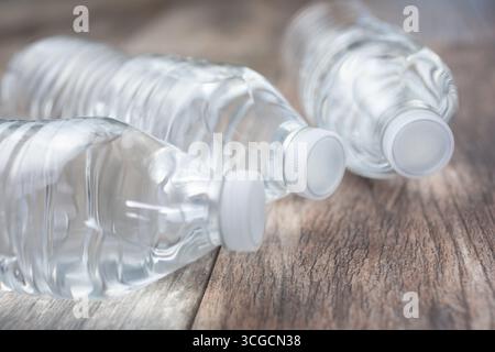 Une vue de trois bouteilles d’eau en plastique sans étiquette, sur une surface en bois. Banque D'Images