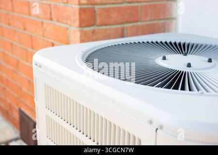 Vue d'un condenseur de climatiseur dans la cour arrière d'une maison. Banque D'Images