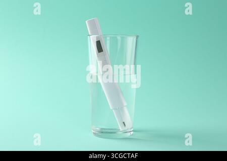 Testeur de nitrate en verre d'eau sur fond turquoise Banque D'Images
