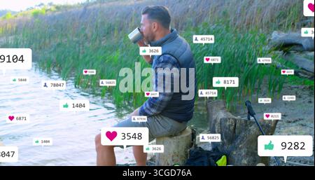Homme en gilet sirotant de tasse de camping sur le moignon du lac, canne à pêche, icônes sociales, espace de copie Banque D'Images