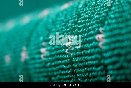 PRODUCTION - 26 août 2025, Saxe, Chemnitz : les tapis coulissants textiles tombent de la machine à tisser de l'usine de production de Mr. Snow à Chemnitz. Environ 13 000 fils se réunissent dans la machine à tisser et sont tissés en boucles flexibles. La structure offre une bonne surface de contact pour les carres des skis. La société basée à Chemnitz dessert désormais tout le spectre du ski, du ski de fond classique aux pistes freestyle. Dimanche (31.08.2025), la dernière installation avec neige textile de Chemnitz ouvrira au Danemark, un terrain de ski de 5 000 mètres carrés à 360 degrés avec six SLO différents Banque D'Images