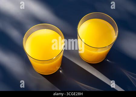 deux verres de jus d'orange sur la table gris ensoleillé Banque D'Images