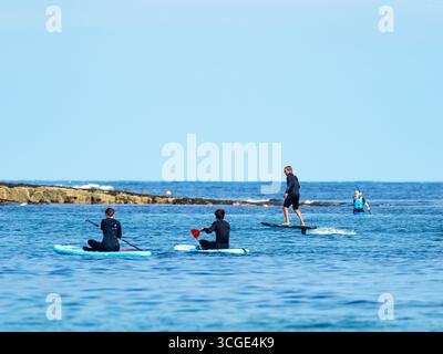 Un homme sur une planche de surf e foil au large de la plage de Beadnell dans le Northumberland, au Royaume-Uni. Banque D'Images