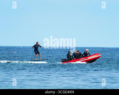 Un homme sur une planche de surf e foil au large de la plage de Beadnell dans le Northumberland, au Royaume-Uni. Banque D'Images