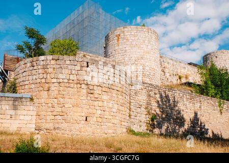 Vue sur les murs médiévaux en pierre et les tours cylindriques du château de Burgos, en Espagne, par une journée ensoleillée, avec des structures métalliques modernes comme une reconfiguration virtuelle Banque D'Images
