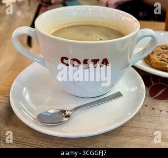Tasse en porcelaine Costa Coffee avec double poignée et logo dans un cadre de café confortable Banque D'Images