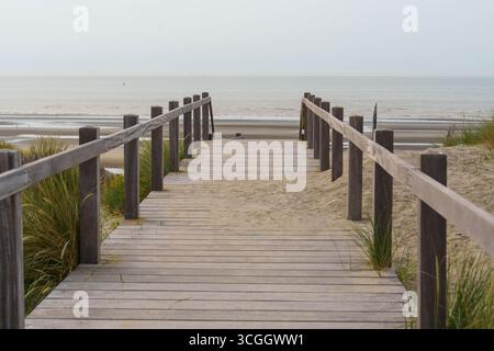 Un sentier en bois menant à travers des dunes de sable à la plage Banque D'Images