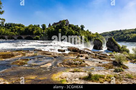 Neuhausen am Rheinfall, Suisse, 10 mai 2025 : vue sur les chutes du Rhin jusqu'au rocher au milieu avec le drapeau suisse. Il n'a pas plu pour un wh Banque D'Images
