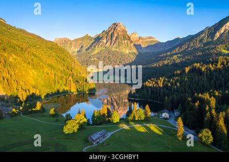 Vue aérienne des sommets Barensoolspitz et Brunnelistock au lever du soleil reflété dans le lac Obersee. Näfels, Oberseealp, canton de Glaris, Suisse. Banque D'Images
