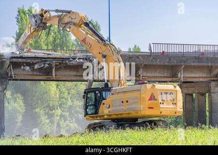 Herserange, France - vue sur une pelle sur chenilles jaunes CAT 374 pour la démolition d'un vieux viaduc routier sur un chantier de construction. Banque D'Images