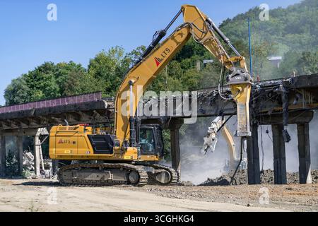 Herserange, France - vue sur une pelle sur chenilles jaunes CAT 374 pour la démolition d'un vieux viaduc routier sur un chantier de construction. Banque D'Images