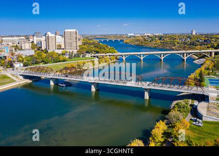 Pont enjambe une rivière avec une ville en arrière-plan. Le pont est vieux et a un aspect rustique Banque D'Images