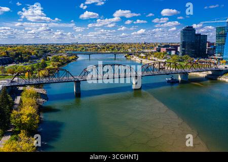 Pont enjambe une rivière avec une ville en arrière-plan. Le pont est vieux et a un aspect rustique Banque D'Images