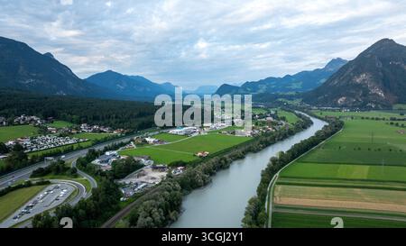 Vue aérienne de la rivière Inn qui traverse une vallée pittoresque des Alpes autrichiennes, entourée de champs verdoyants, de forêts et de montagnes Banque D'Images
