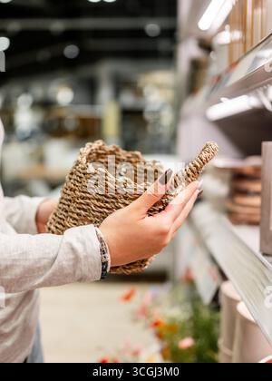 Mains de femme tenant le panier tissé dans le magasin gros plan et shopping dans le supermarché Banque D'Images
