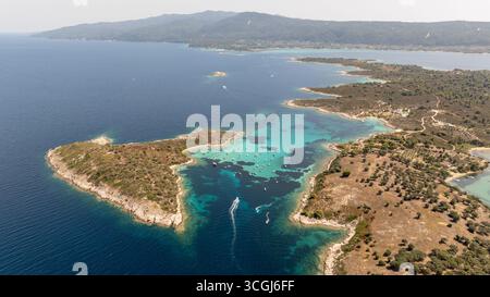 Vue aérienne de l'île de Diaporos avec des bateaux mouillant dans l'eau turquoise, Vourvourou, Sithonia, Grèce Banque D'Images
