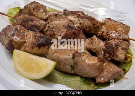 Prise du jour, thon grillé sur des brochettes sur le marché quotidien aux poissons de Marsala, Sicile, savoureux repas de rue en Italie, gros plan Banque D'Images