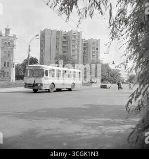 Photos d'archives d'un carrefour animé à Sloviansk, 1987, avec un trolleybus ZiU-9 et un bus LAZ sur fond d'architecture soviétique contrastée, symbole de la vie urbaine dynamique et paisible du Donbass avant la guerre Banque D'Images