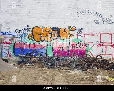 Un hodgepodge de graffitis colorés orne un mur blanc avec des câbles sur le sol Mariahilferstrasse Vienne Autriche Banque D'Images