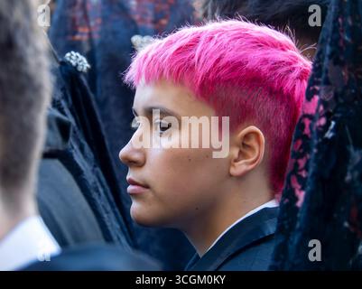 Leon, Espagne. 14 avril 2025. Plan de profil en gros plan d'un jeune homme aux cheveux rougeâtres, attendant dans la rue pour participer aux processions de la semaine Sainte. Banque D'Images