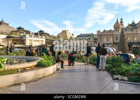 Touristes dans les jardins du Casino admirant la place du Casino décorée d'arbres de Noël pendant les vacances d'hiver, Monte Carlo, Principauté de Monaco Banque D'Images