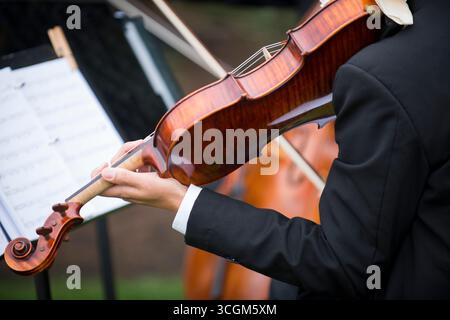 Violoniste en tenue formelle jouant à l'événement extérieur avec la feuille M. Banque D'Images