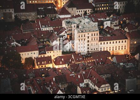 Vue aérienne d'un paysage urbain serré brille de lumière chaude contre le crépuscule qui s'approfondit, mettant en valeur les toits de tuiles rouges, la cathédrale de Zagreb, et les bâtiments historiques, Zagreb, Zagreb, Zagreb, Croatie. Banque D'Images
