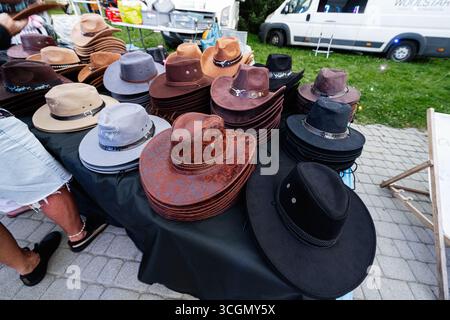 Rzeszow, Pologne - 22 août 2025 : variété de chapeaux exposés sur la table d'un vendeur sur un marché de Rzeszow, Pologne Banque D'Images