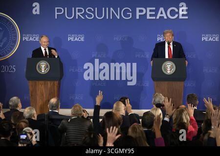 Anchorage, États-Unis d'Amérique. 15 août 2025. Le président américain Donald Trump, à droite, prononce des remarques alors que le président russe Vladimir Poutine, à gauche, regarde lors d’un communiqué de presse conjoint à la conclusion du sommet américano-russe à la base conjointe Elmendorf Richardson, le 15 août, à Anchorage, en Alaska. Crédit : Alejandro Peña/US Army photo/Alamy Live News Banque D'Images