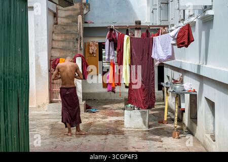 Monastère Mahagandayon Monk and Laundry Mandalay Myanmar // MANDALAY, Myanmar — Un moine bouddhiste est vu faire la lessive au Monastère Mahagandayon, un collège monastique de premier plan situé à Mandalay, Myanmar. Le monastère est l'un des plus grands du pays, abritant des milliers de moines et de novices qui consacrent leur vie à l'étude des écritures et des pratiques bouddhistes. Les routines quotidiennes comme laver les robes font partie intégrante de la vie monastique. Le monastère Mahagandayon (également connu sous le nom de monastère Mahagandayone) est un centre important pour l'éducation bouddhiste Theravada dans la région de Mandalay. Banque D'Images