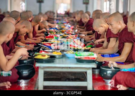 Monastère de Mahagandayon déjeuner salle à manger des novices Mandalay Myanmar // MANDALAY, Myanmar — les novices du monastère de Mahagandayon se réunissent pour leur déjeuner commun quotidien dans la salle à manger. Ce repas est un élément central de la routine monastique et un événement important pour la grande communauté du monastère. Le monastère de Mahagandayon est l'un des collèges monastiques les plus grands et les plus respectés du Myanmar, qui abrite des milliers de moines et de novices. Situé à Amarapura, près de Mandalay, c'est un centre vital pour l'étude du bouddhisme Theravada. Le monastère joue un rôle crucial dans la vie spirituelle et éducative de Mandal Banque D'Images