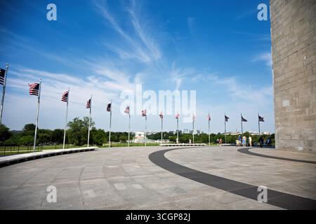 Washington Monument Fifty American Flags National Mall Lincoln Memorial View Washington DC // WASHINGTON DC — cinquante drapeaux américains entourent la base du Washington Monument sur le National Mall, avec le Lincoln Memorial visible au loin. Cet obélisque emblématique rend hommage au premier président des États-Unis, George Washington, et est un point de repère important dans la capitale du pays. Construit à partir de marbre, granit et gneiss de pierre bleue, le monument mesure 169,29 mètres (555 pieds 5 1/8 pouces) de haut, ce qui en fait l'obélisque le plus haut du monde. Achevé en 1884, il est un élément clé du National Mall et Memoria Banque D'Images