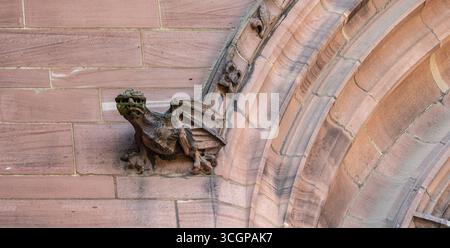 Ancienne sculpture gothique en gargouille sculptée dans la pierre, située sur une arche ornée de la cathédrale, mettant en valeur l'art architectural médiéval. Banque D'Images