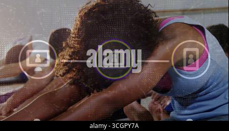 Femme pliante en haut bleu effectuant un étirement de flexion avant au studio de yoga, avec des tapis et des icônes UI Banque D'Images