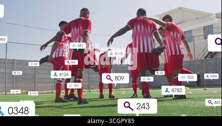 Huit joueurs de football en maillots rouge-blanc s'étirant sur du gazon, avec des cônes orange et des icônes superposées Banque D'Images