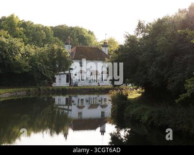 Beau chalet au bord du canal reflété dans le canal dans la lumière du soir près de Tring dans le Hertfordshire, Angleterre. 29 août 2025 Banque D'Images