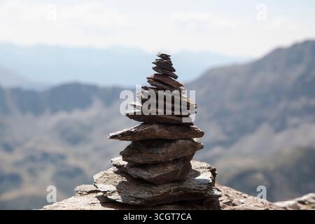 Un tas de pierres avec une vue dégagée sur une vallée montagneuse Banque D'Images